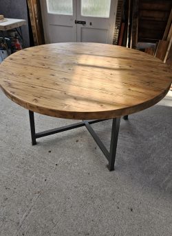 Solid, circular pine table with metal base.